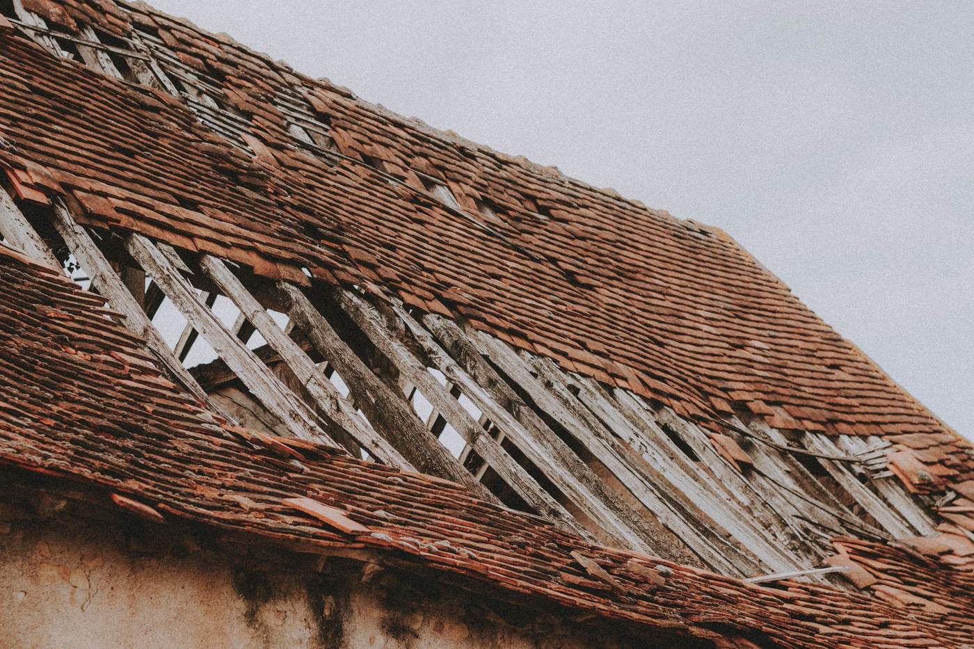 Close-up of roof damage showing deteriorated shingles with missing sections and wear