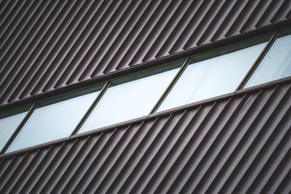 Metal roofing installation showing standing seam details on residential house
